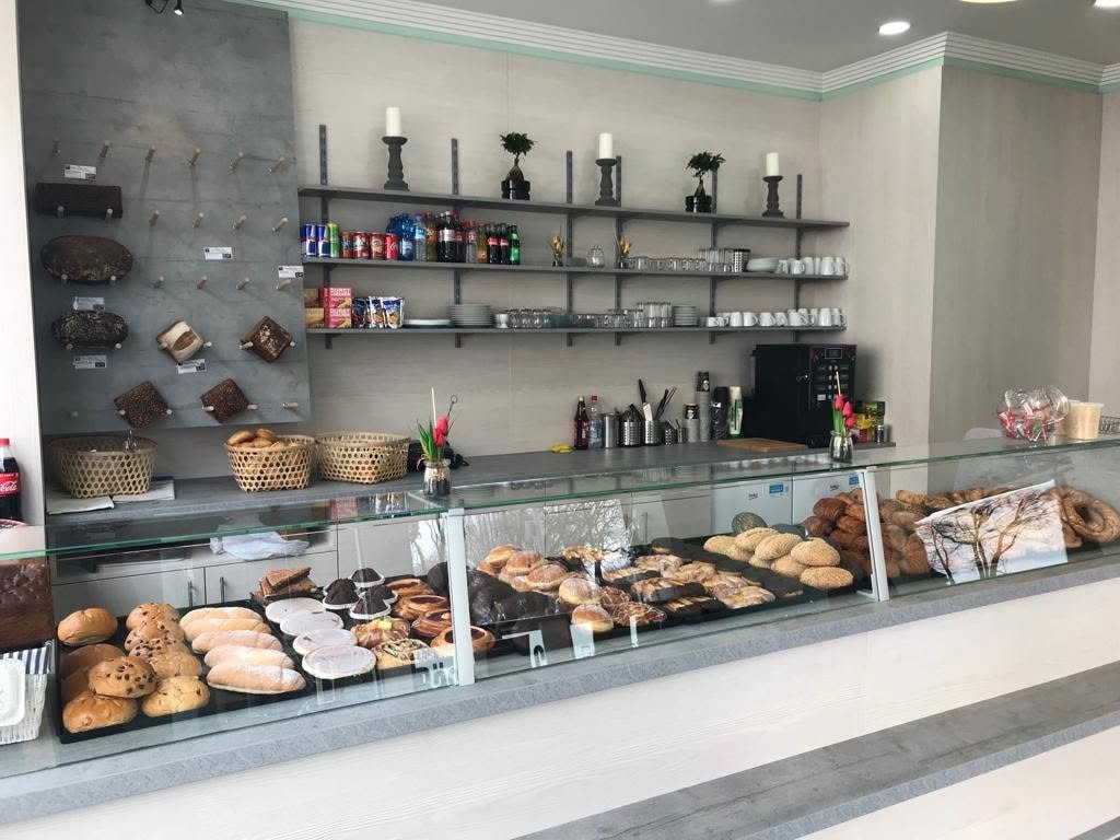 Verkaufstheke mit Glasvitrine und Wandregalen in einem modernisierten Ladenlokal