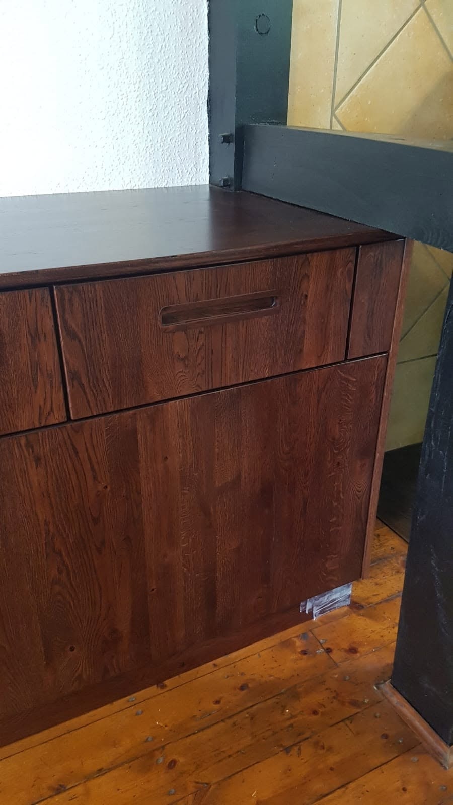 Schubladenfront aus dunklem Massivholz mit eingelassenem Griff